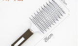 An image showing a 26 cm white and grey ExZachly Perfect Hairbrush Anti Klit Brushy Haarborstel with a cushioned base and widely spaced bristles. The handle, featuring a textured, non-slip grip in a dark color, also promotes gentle scalp massage.