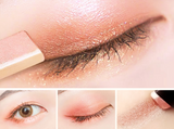 A close-up collage of eye makeup application. The top image shows a brush applying ExZachly Perfect Two-tone eye shadow stick lazy eye shadow to a closed eyelid, perfect for neutral skin types. The bottom images display an eye without makeup, with eyeshadow applied, and a lipstick-like applicator with the same waterproof eyeshadow shade.